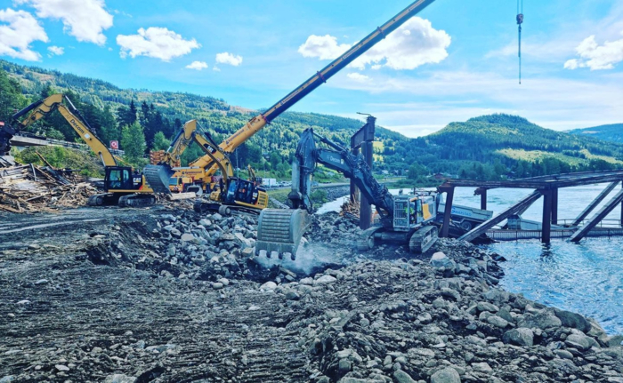 FORARBEID: Det var mye forarbeid som måtte gjøres for å få bilen trygt av brua. Området rundt brua ser ut som et anleggsområde. Foto: Gudbrandsdal Bilberging